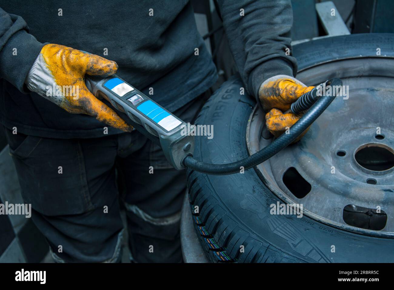 The service person measures the air pressure of the new tire Stock Photo