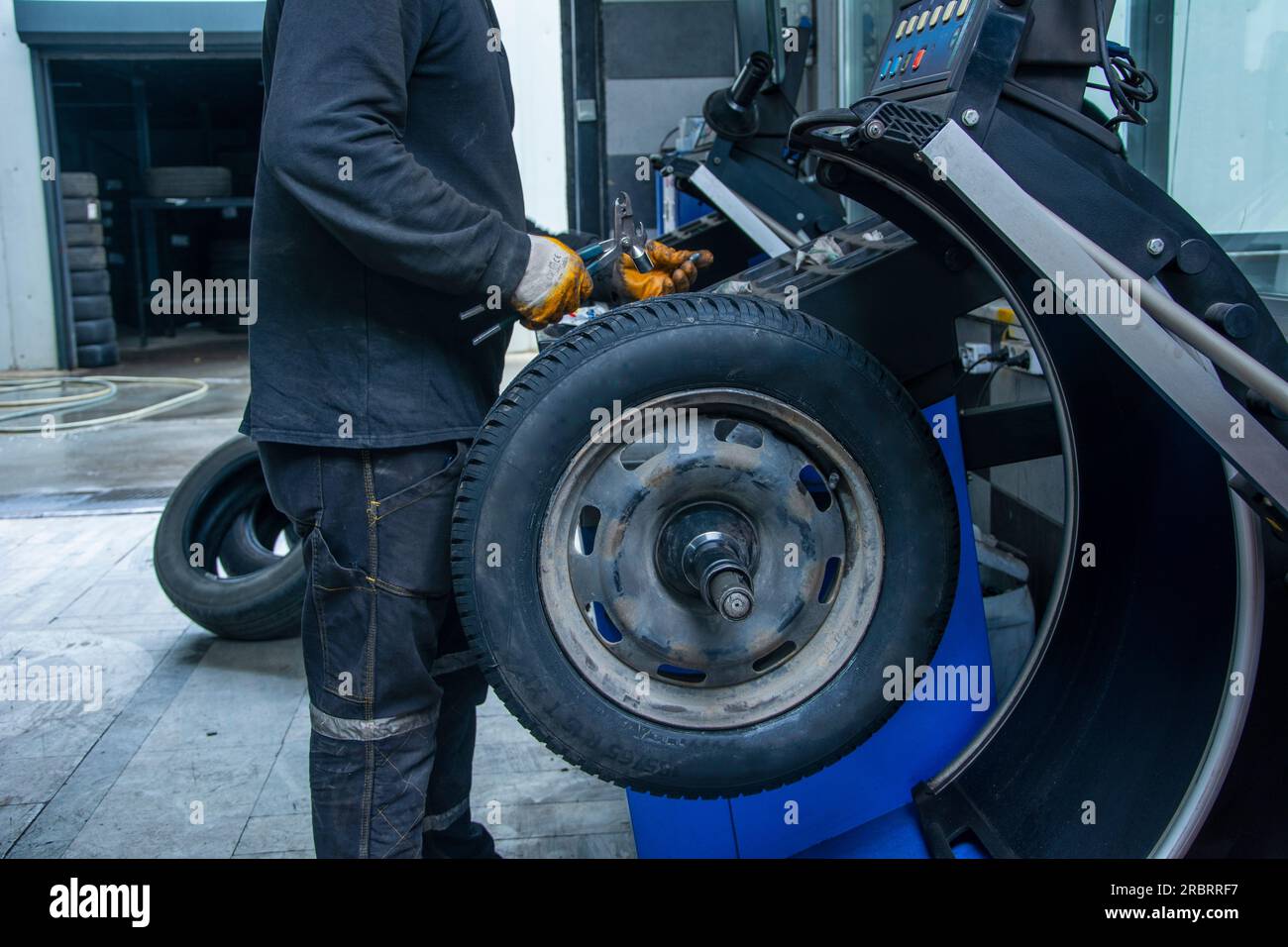Unrecognizable service man makes new wheel balancing Stock Photo