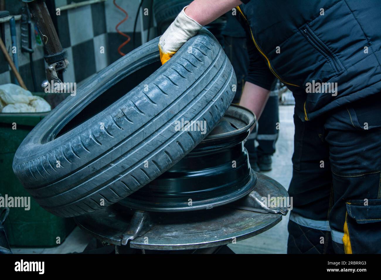 View of the service worker with the tire removed from the rim Stock Photo