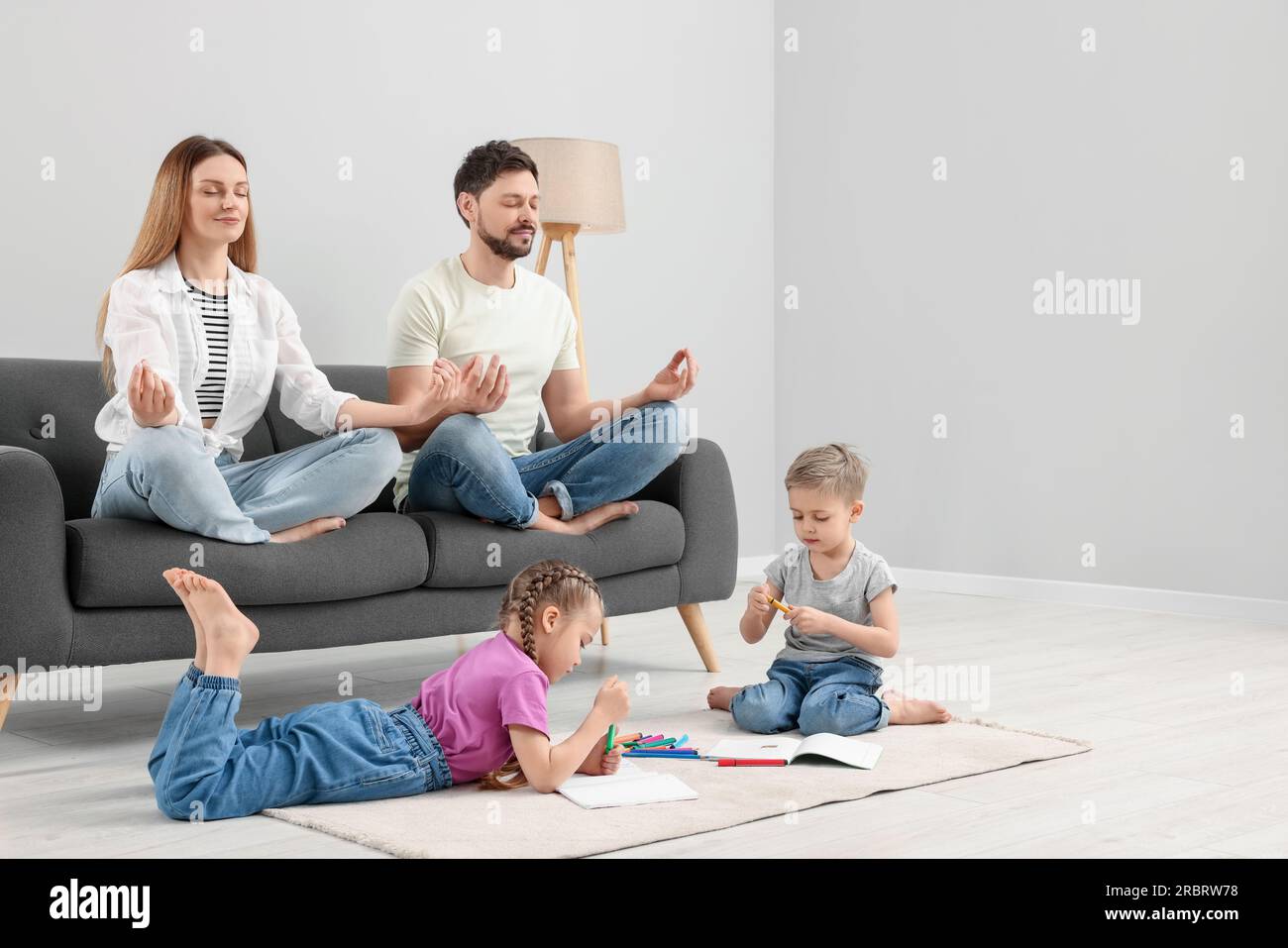 Parents meditating while their children painting at home Stock Photo