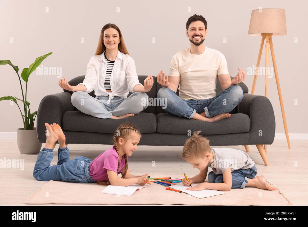 Parents meditating while their children painting at home Stock Photo