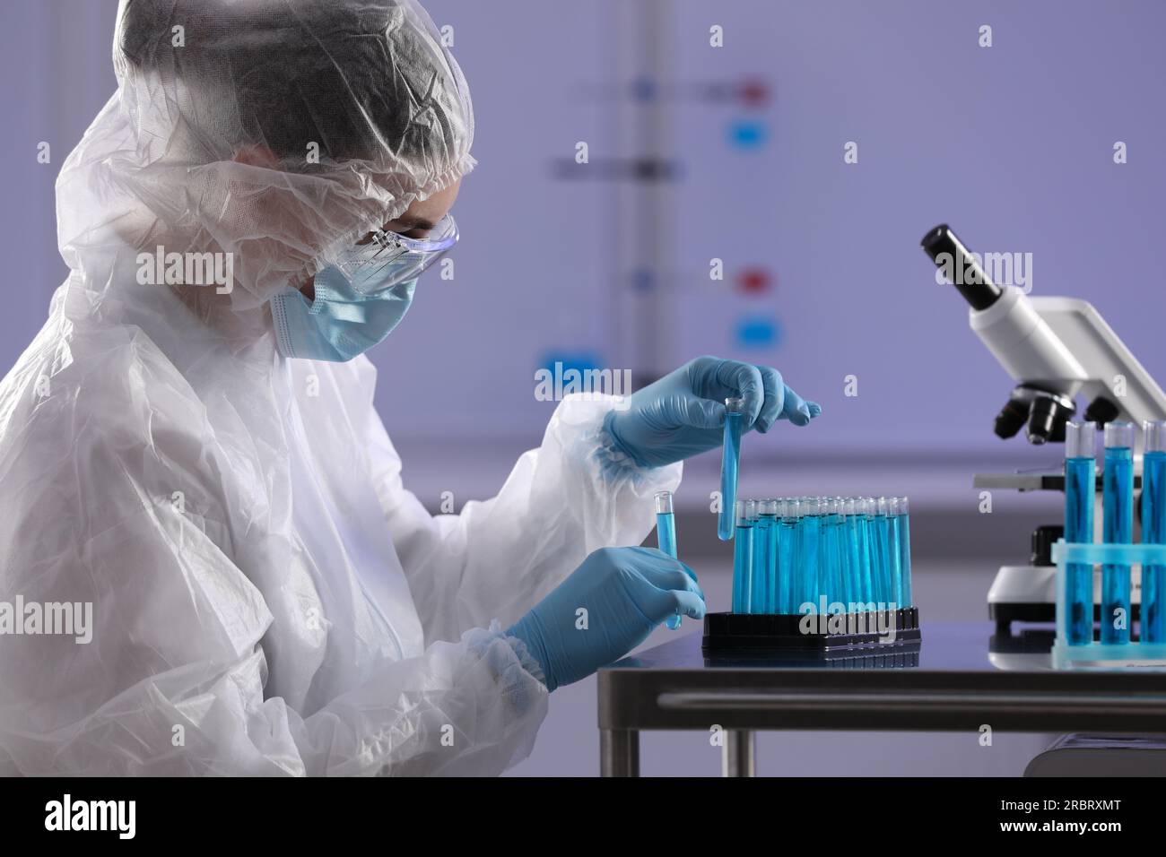 Scientist holding test tubes with light blue liquid in laboratory Stock ...