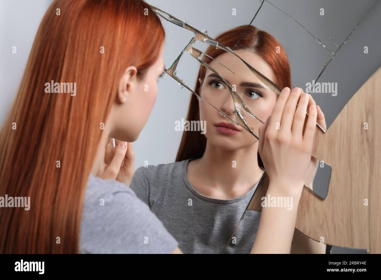 Sad young woman suffering from mental problems near broken mirror Stock ...