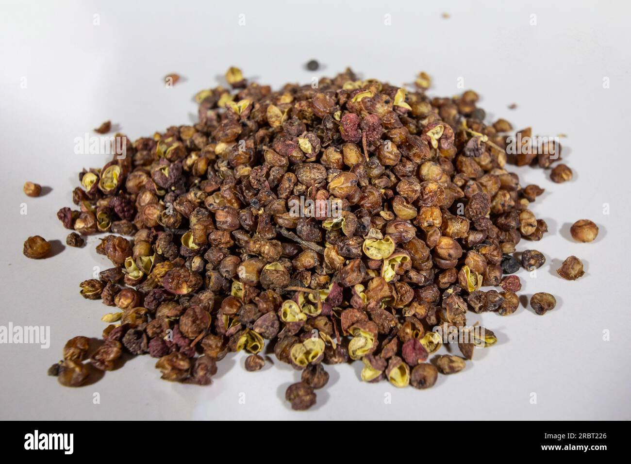 Picture of chinese sichuan pepper on a white plate , piled in stacked. Sichuan pepper also known as Szechuan pepper, Szechwan pepper, Chinese prickly Stock Photo