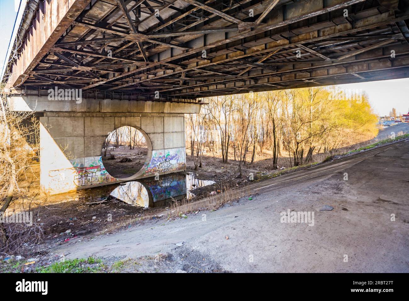 Kiev, Ukraine, March 30, 2014, Under the Moscovsky bridge in Kiev, Ukraine. The old metal structure is attacked by rust. Grafitti are painted on the Stock Photo