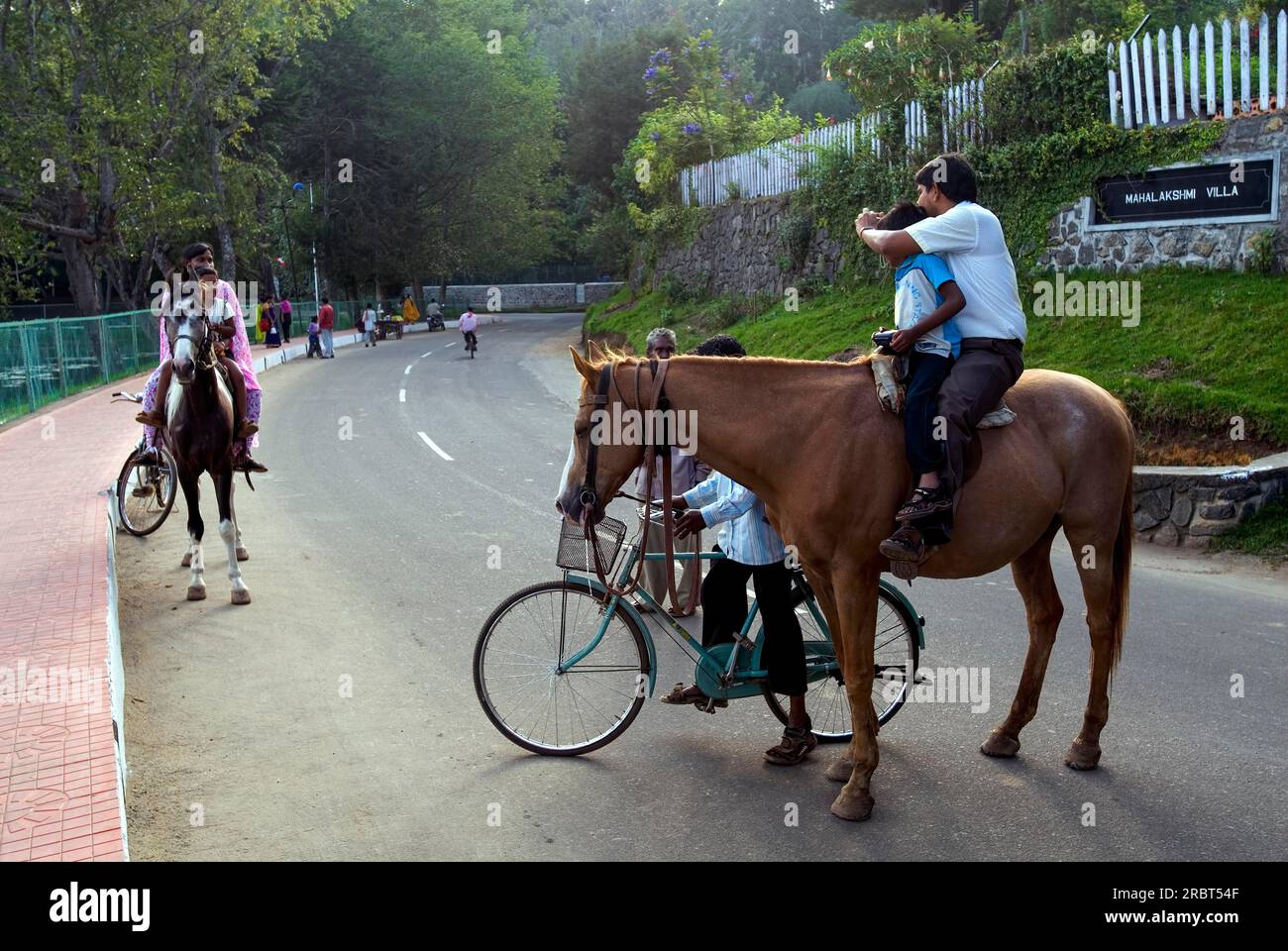 A horse rider taking photo of horse riding Tourists at Kodaikanal