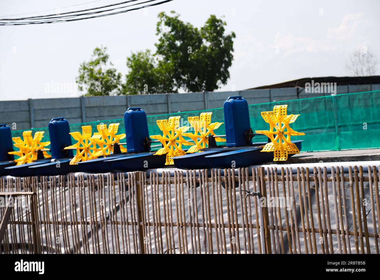 Several paddle wheel aerators undergo maintenance and repair before being installed in a shrimp and fish cultivation pond Stock Photo