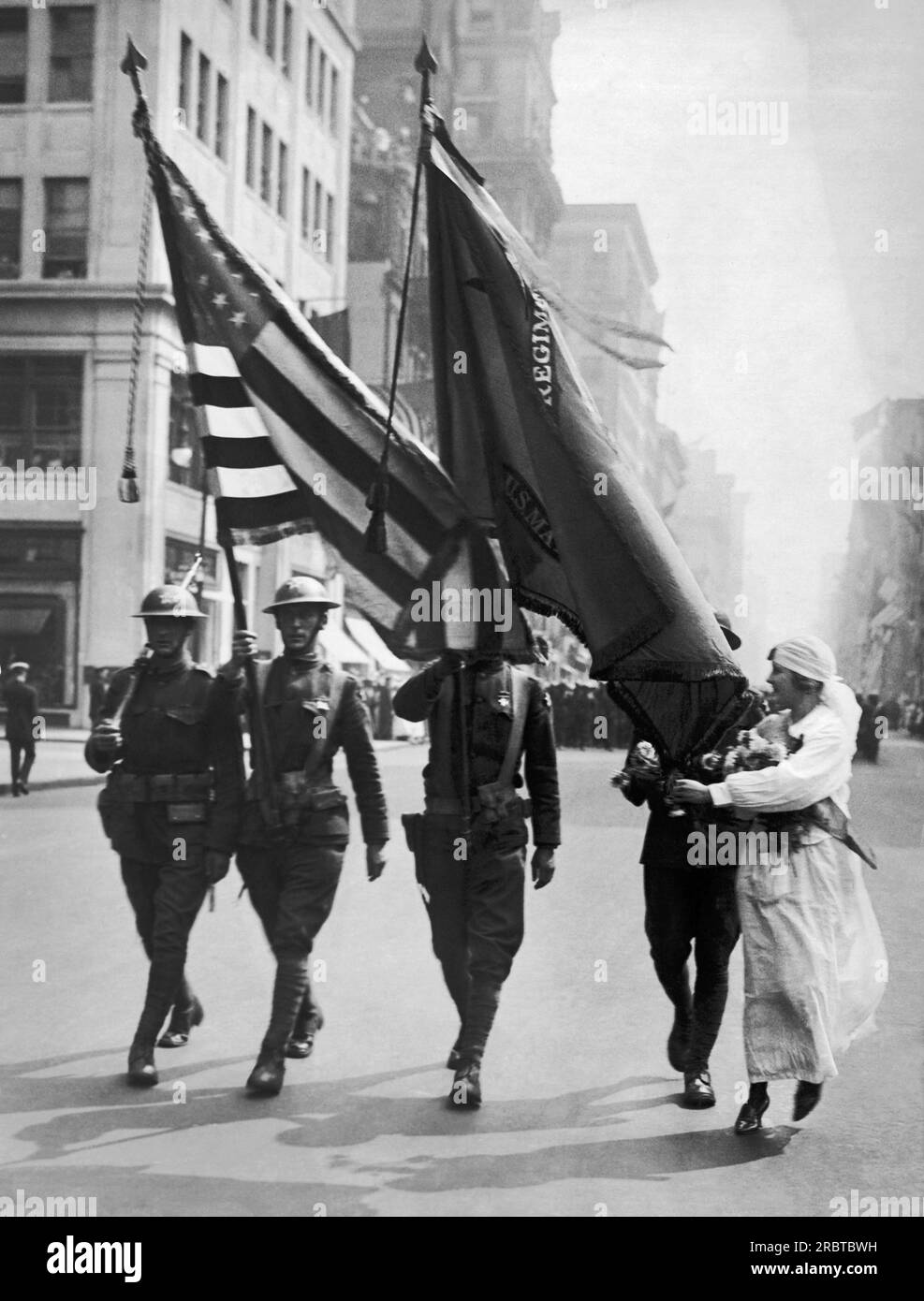 New York, New York:  August 7, 1919 A Knights of Columbus girl giving  flowers to the color guard of the Second Division in the great Welcome Home Parade today. Stock Photo