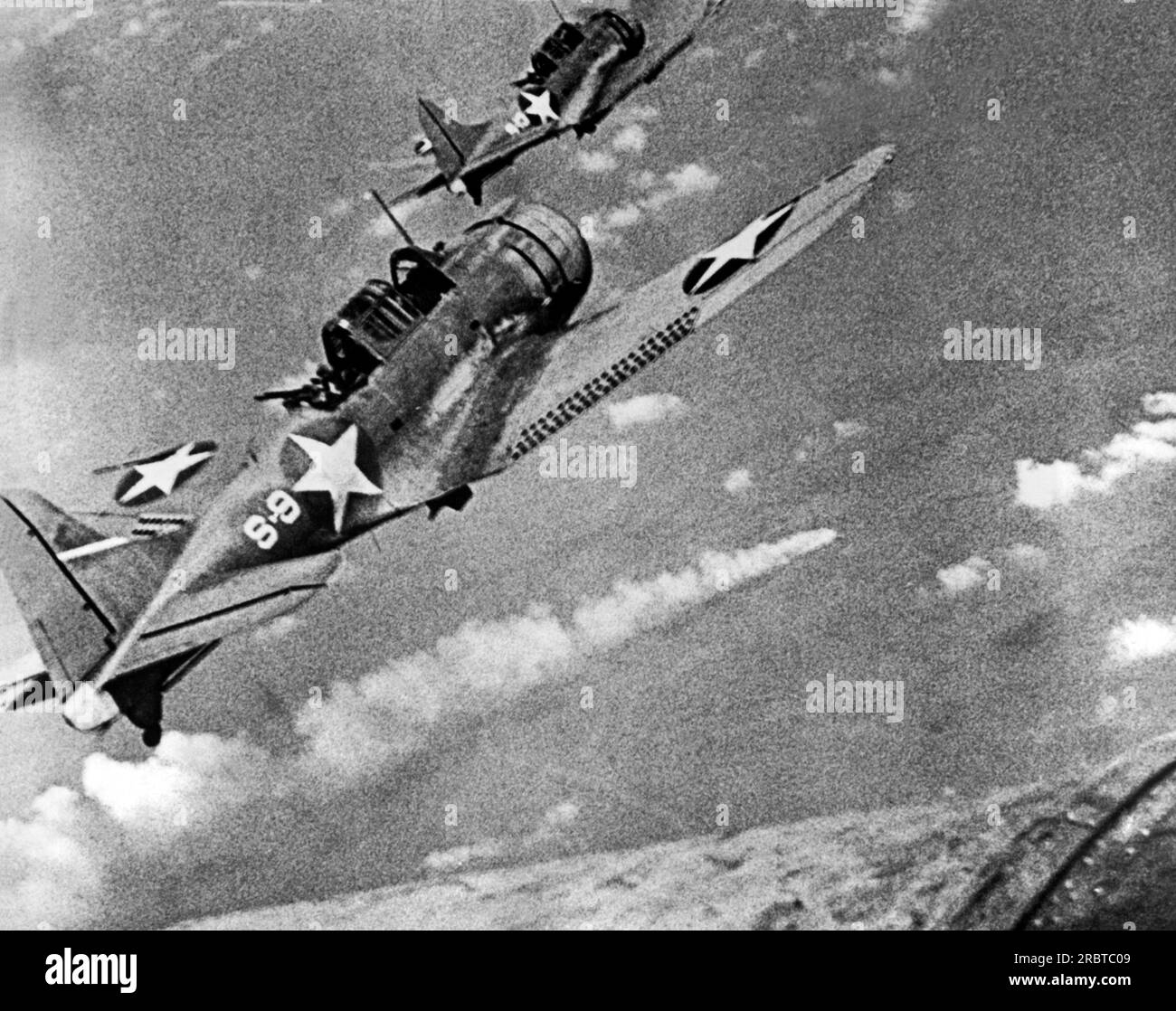 Midway Island,  June, 1942 Two US fighter planes fly over a burning Japanese ship during the Battle of Midway. Stock Photo