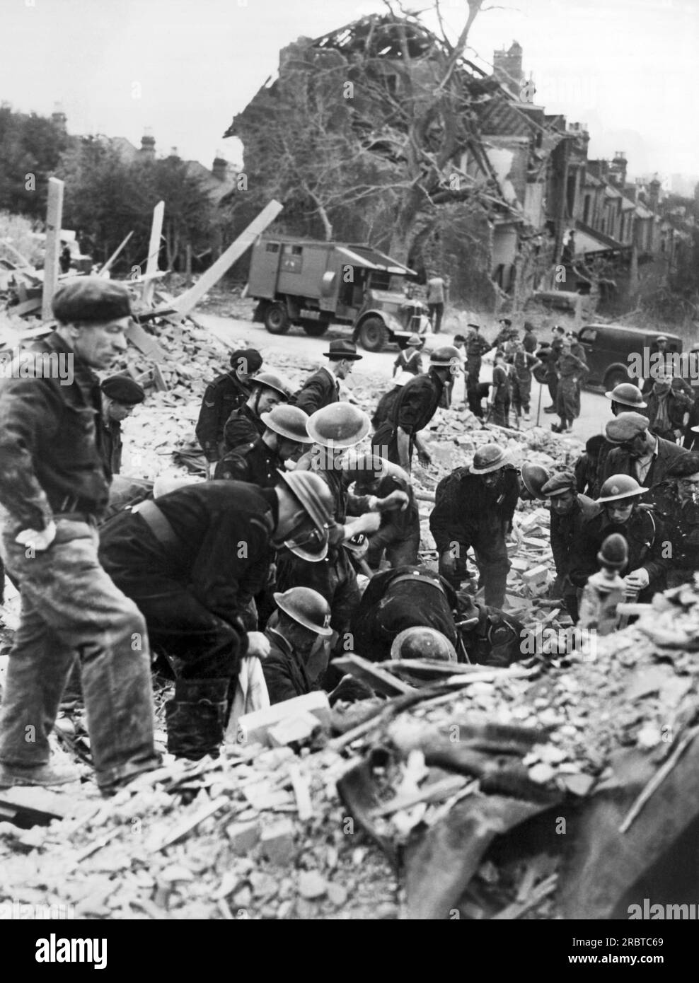 London, England:  c. 1943 Civil Defense rescue workers searching the ruins for victims and survivors after a German V-1 flying bomb hit London's Balham district. Stock Photo