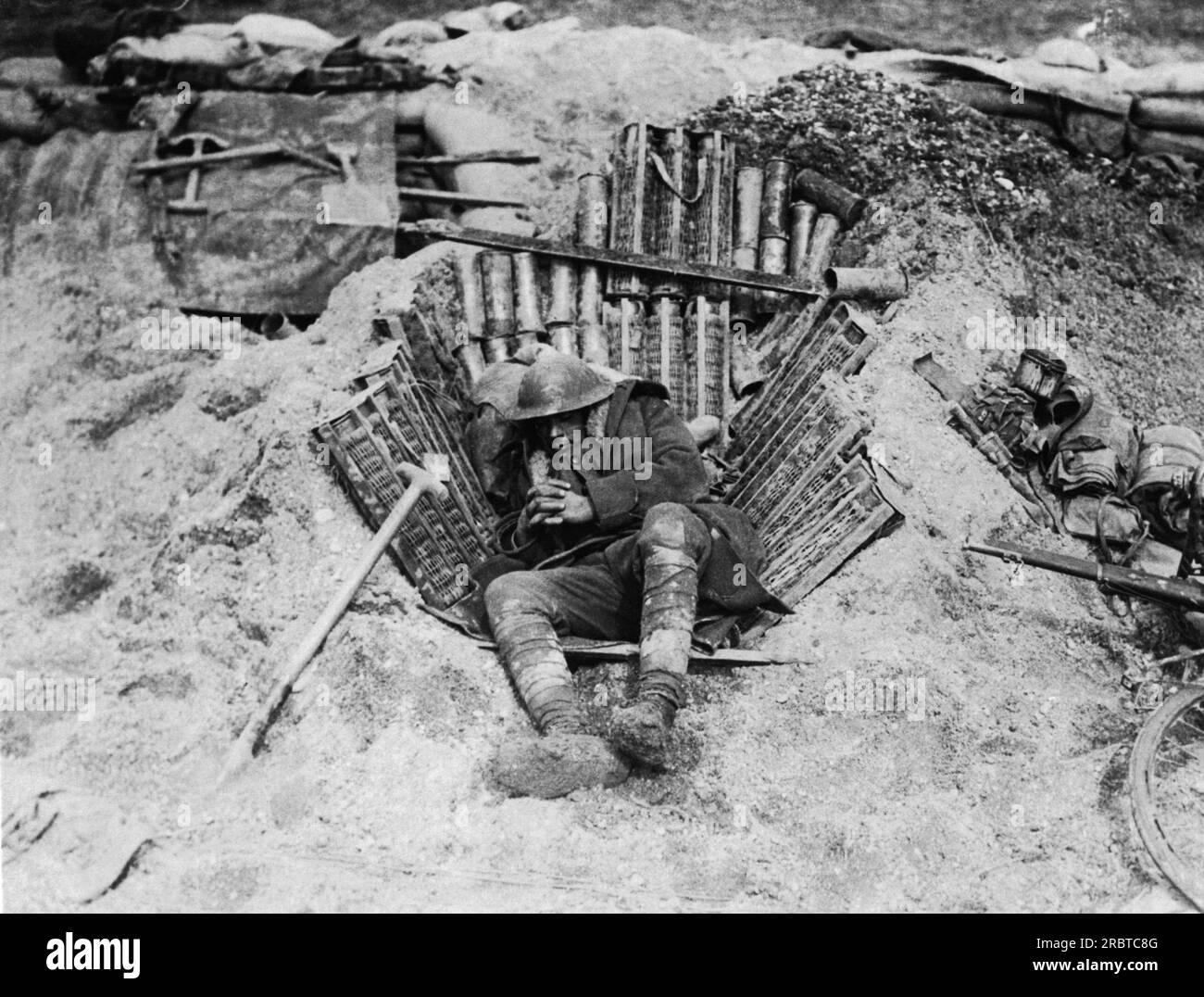 Europe: c. 1917 An exhausted soldier in WWI curls up to sleep using ...