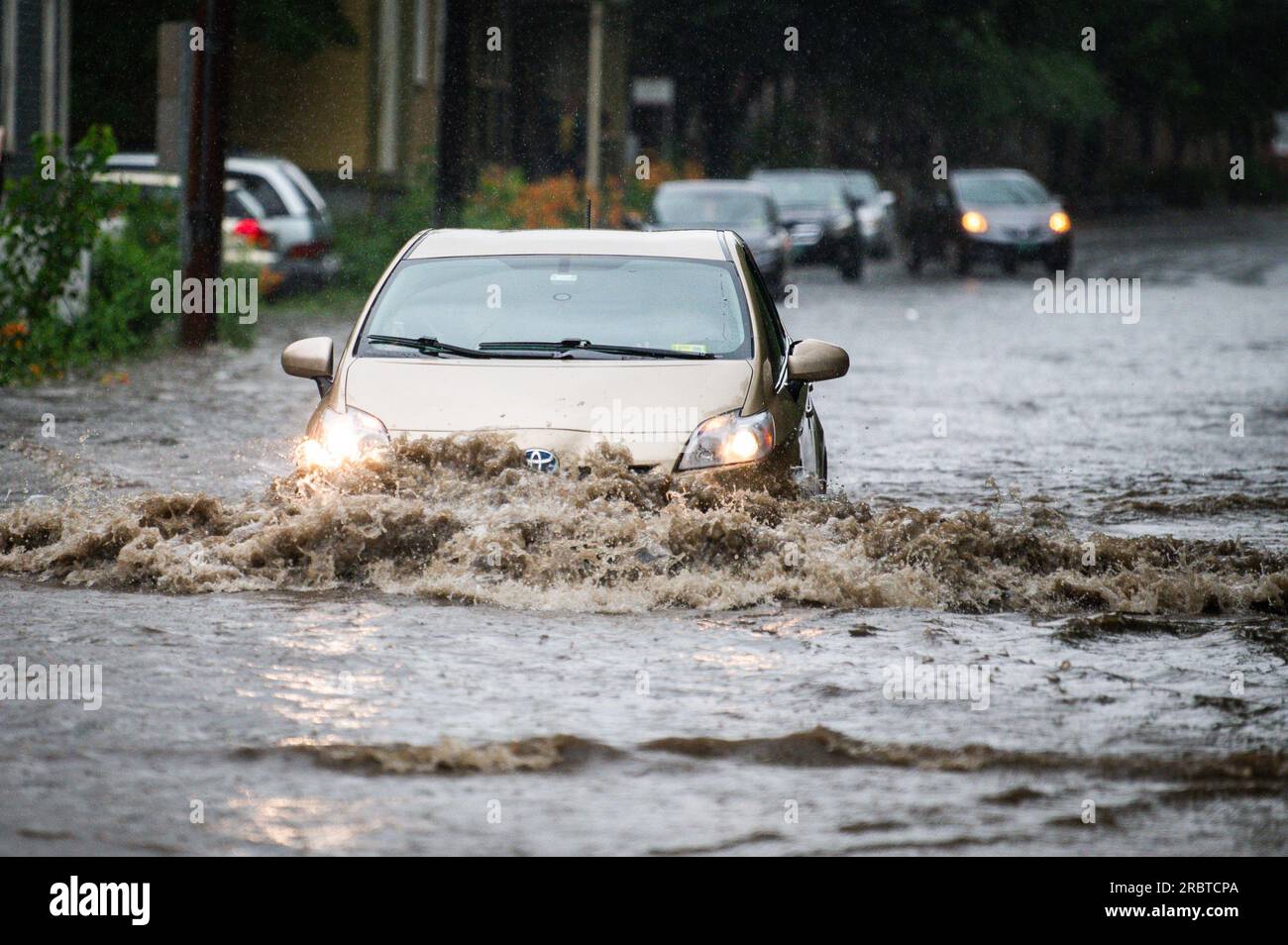 Vermont, New England, USA. 10th July, 2023. Vehicle navigates flooded Elm Street in Montpelier Vermont, USA, as floodwaters from the Winooski River began to rise in Vermont's capital.  10 July, 2023. Credit: John Lazenby/Alamy Live News Credit: John Lazenby/Alamy Live News Stock Photo