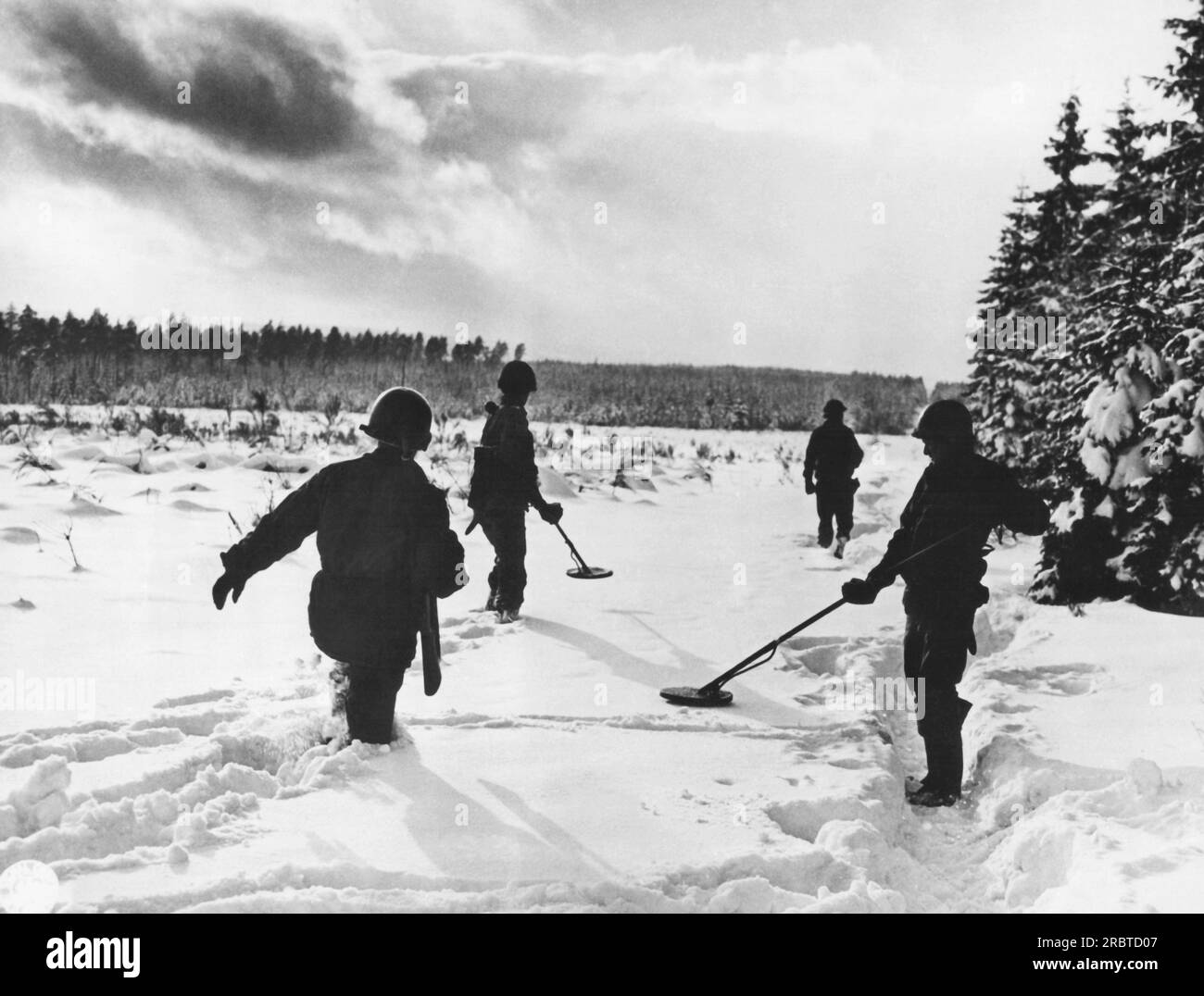 Commanster, Belgium, February 1, 1945 Engineers of the 75th Division stand knee high in a snow covered road as they search for enemy mines before tanks move up to attack at Commanster. Stock Photo