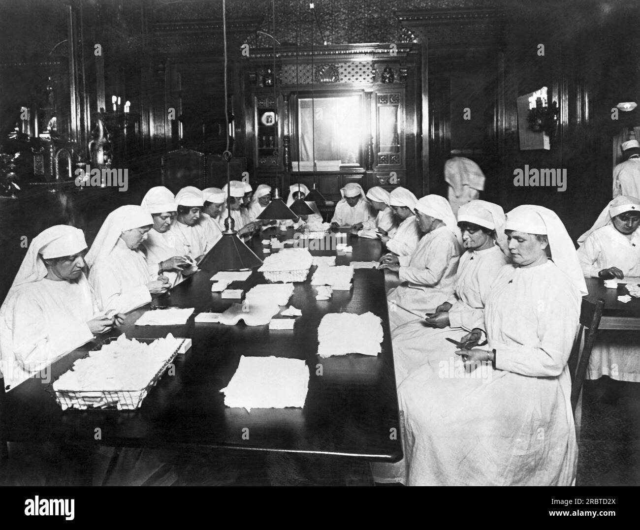 New York, New York:   c. 1917 Members of a Red Cross auxiliary chapter make surgical dressings for the war in the home of John D. Rockefeller on 54th Street in New York. Stock Photo