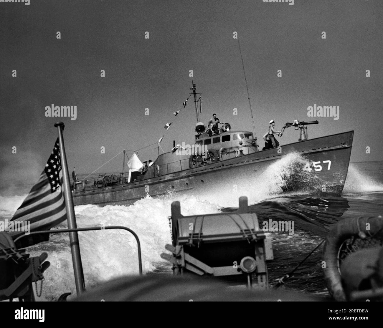 South Pacific Ocean,  circa 1943 A US Coast Guard sub-buster on convoy patrol as it passes by another Coast Guard patrol boat loaded with depth charges on its stern. Stock Photo