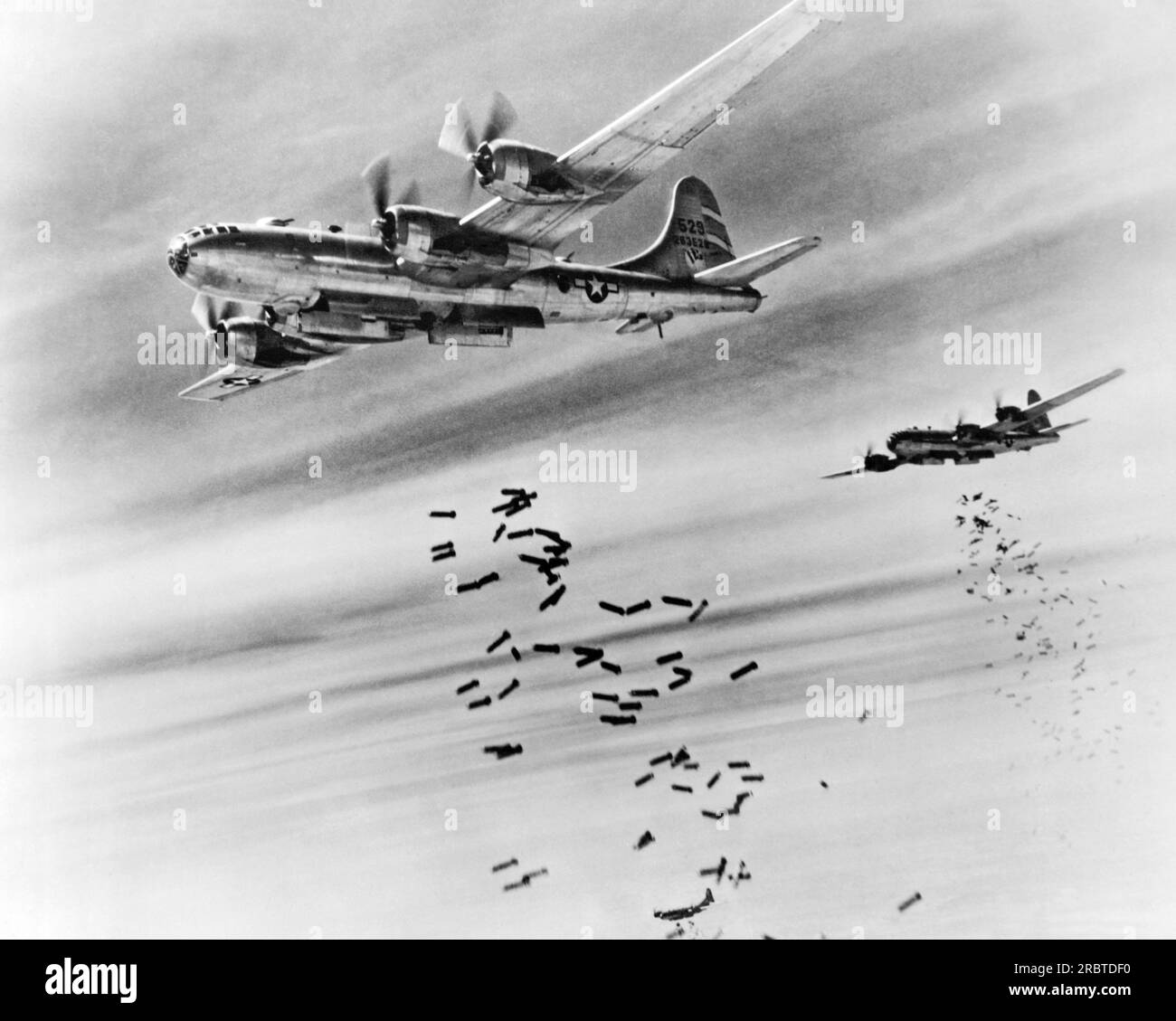 Burma:  February 28, 1945 Bombs cascade from the bomb bay doors of B-29 Superfortresses during a raid on the Japanese supply depots near the Mingaladon Air Field. Stock Photo