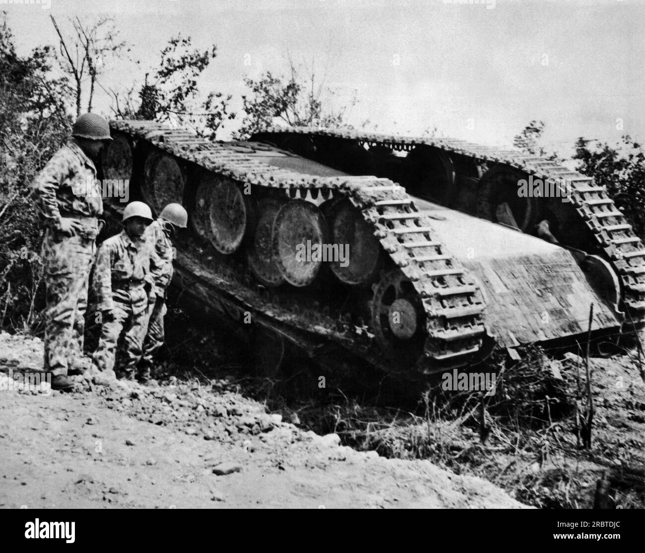 Normandy, France, 1944 American soldiers dressed in new type camouflage uniforms looking at German Tiger Tank. Stock Photo