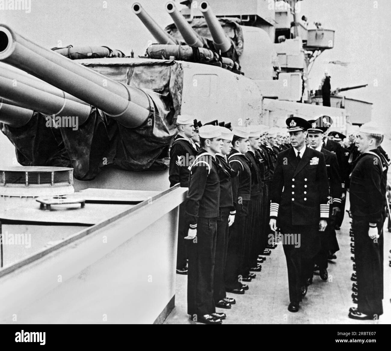 England:  June, 1944 King George VI of Great Britain moves down the line on an inspection tour of one of HMS Royal Navy warships. Little did the sailors know that the King was giving them a final inspection before D-Day. Stock Photo