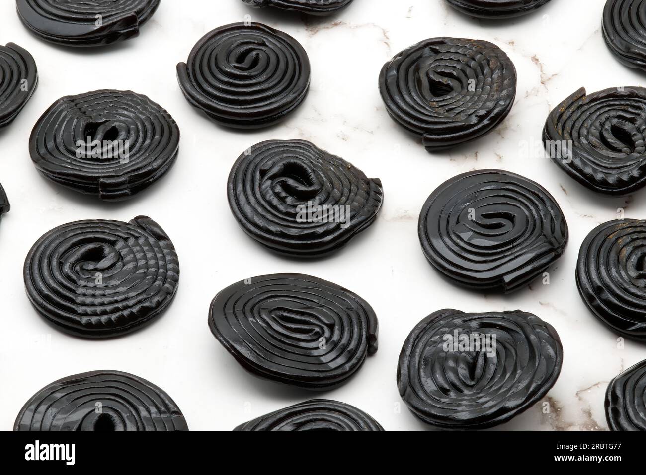 Tasty black licorice candies on white marble background Stock Photo - Alamy
