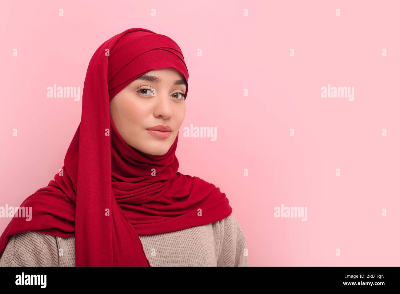 Portrait of Muslim woman in hijab on pink background, space for text ...