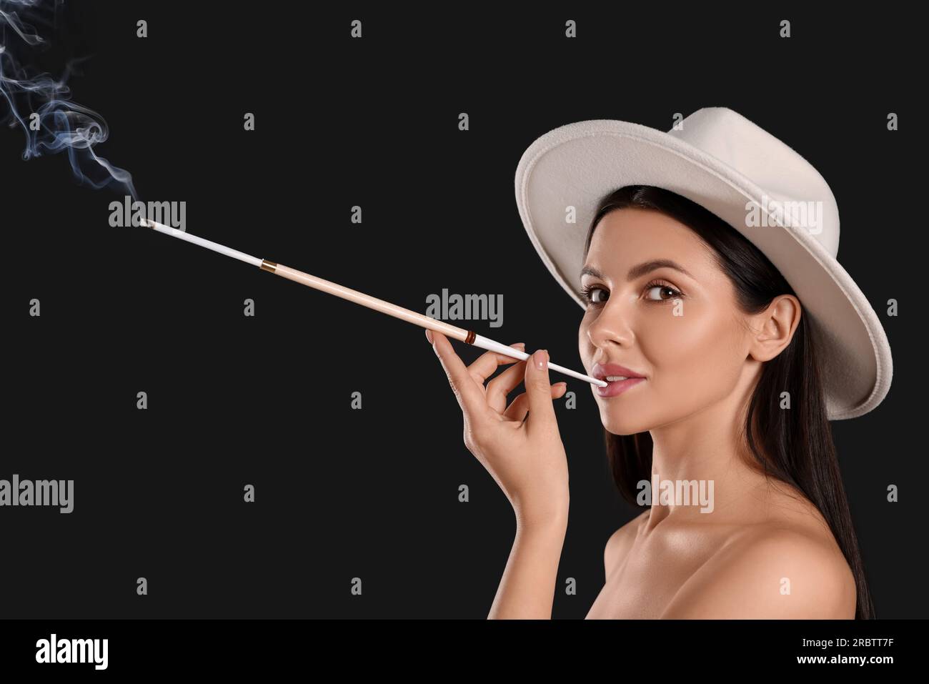 cigarette holder for smoking Woman using long cigarette holder for smoking on black background Stock  Photo