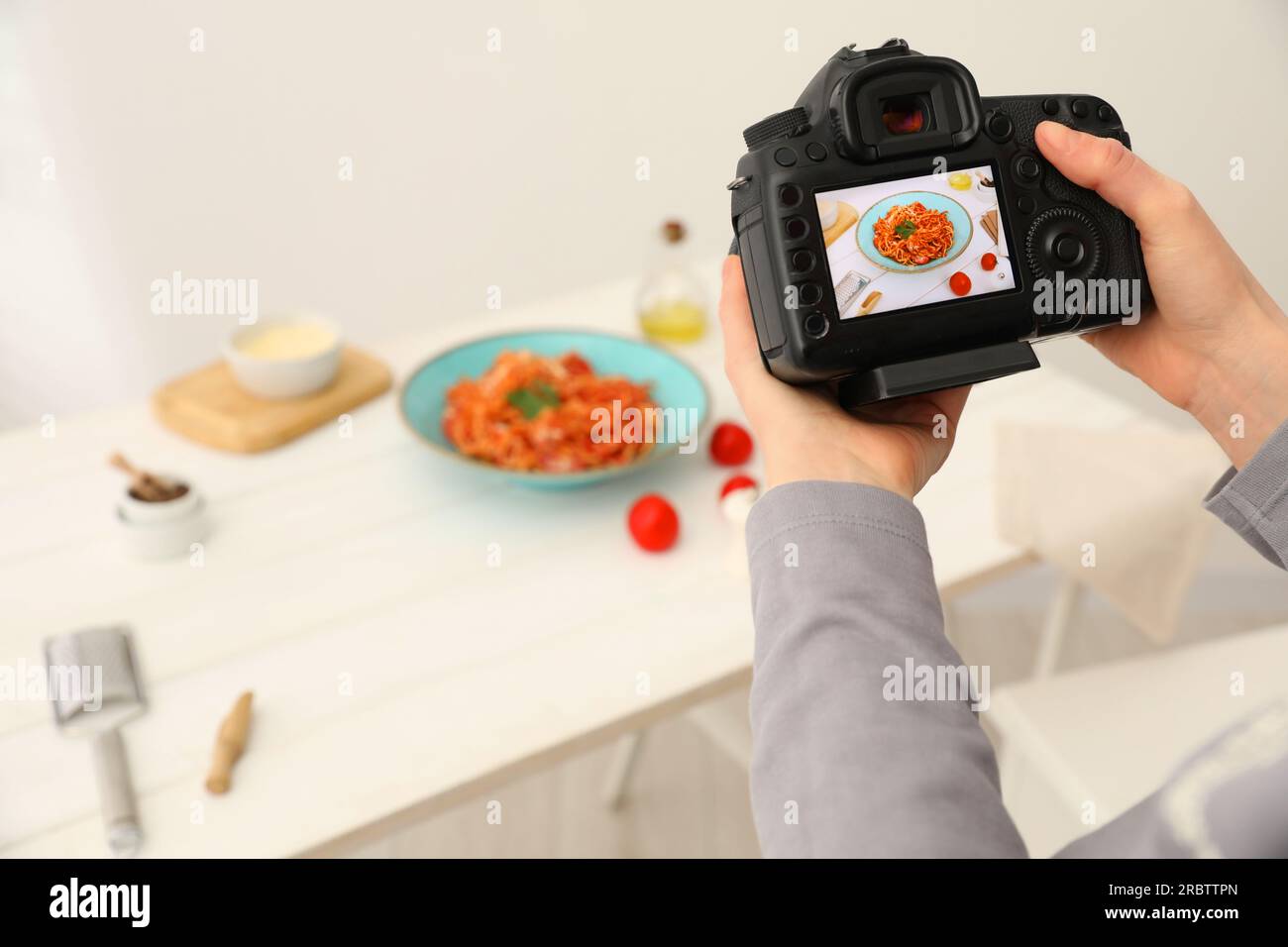 Food stylist taking photo of delicious spaghetti in studio, closeup. Space for text Stock Photo