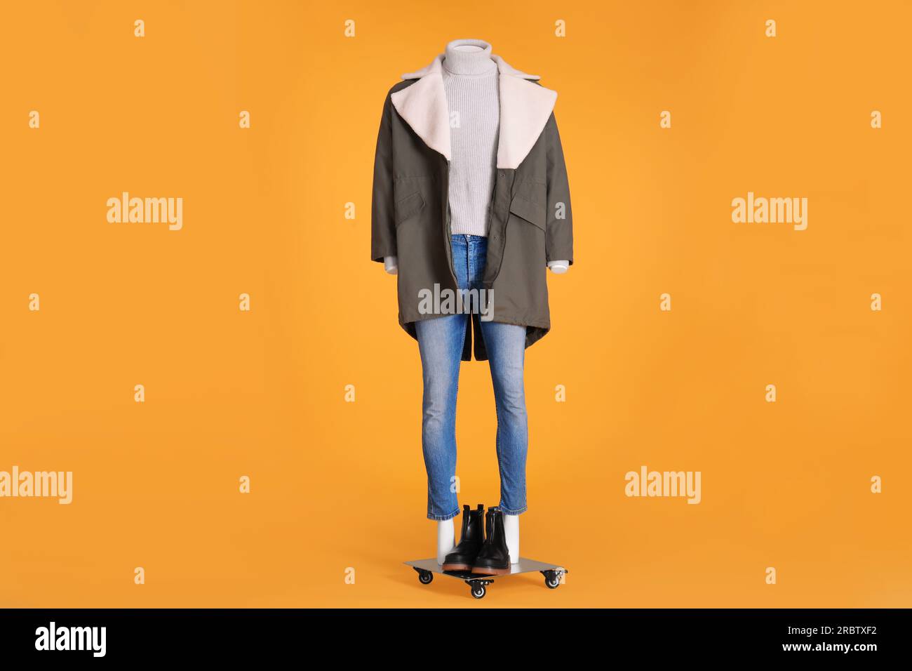 Female mannequin with boots dressed in stylish jacket, turtleneck and