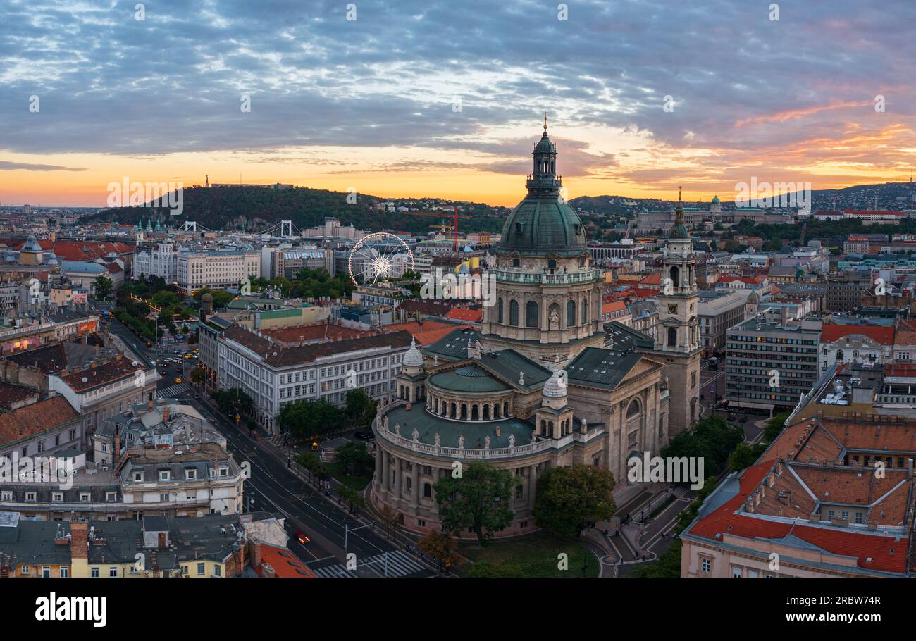 Aerial skyline view about the famous St. Stepehen's Basilica in the downtown of Budapest. Aerial cityscape. Spectacular sunset over Buda hills. Stock Photo