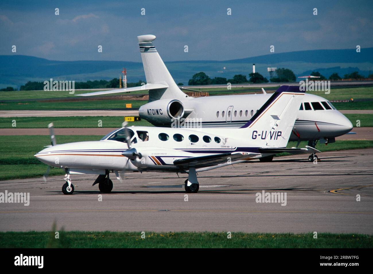 An executive, business, private Jet aircraft, a Dassault Falcon 50, registered in the USA as N701WC, together with a Cessna 421C twin engined business turbo prop aircraft, registered in UK as G-UVIP. Stock Photo