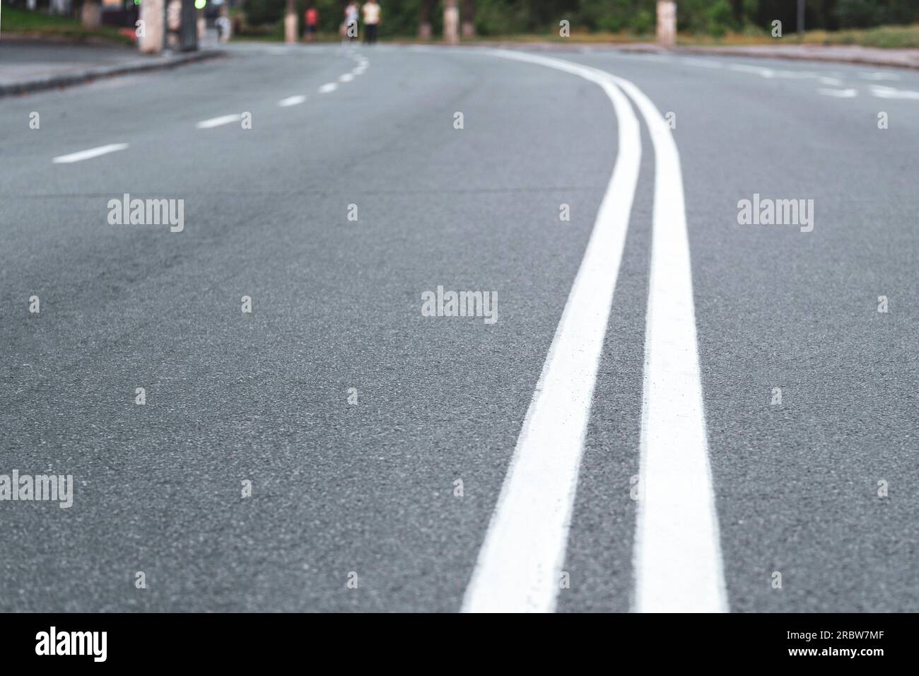 The asphalted road with two continuous white strips. The highway with a white marking. Turn on