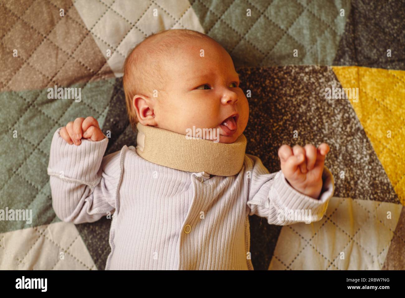 Cute newborn baby in a neck brace. Kid wearing cervical collar