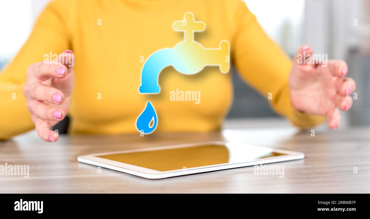 Digital tablet with water leak concept between hands of a woman in background Stock Photo