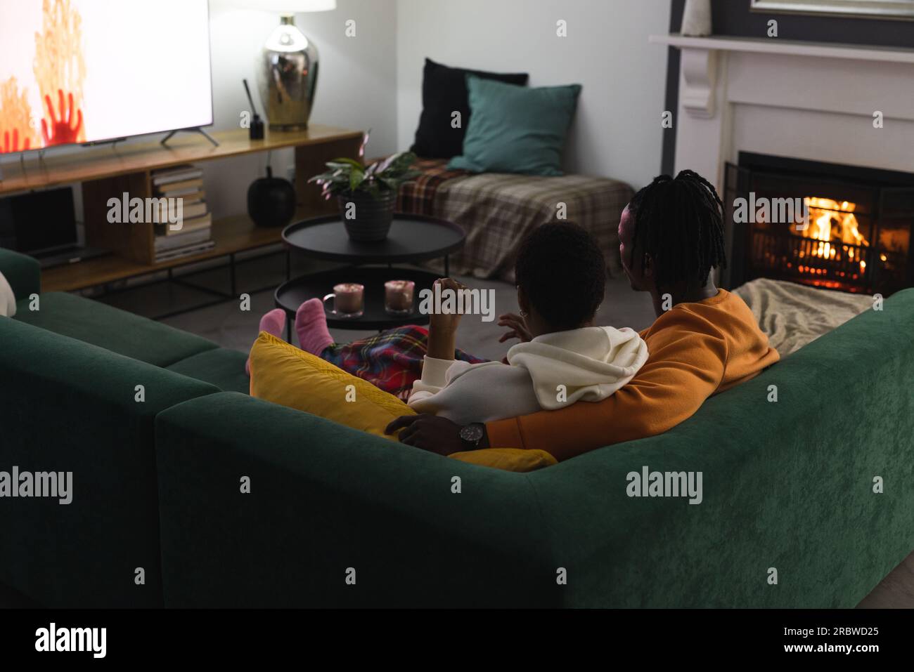 African american couple relaxing at home watching tv Stock Photo - Alamy