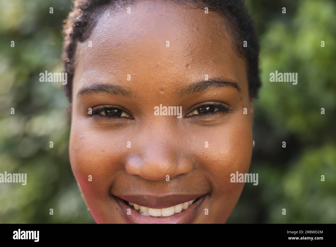Portrait of happy african american woman in sunny garden Stock Photo ...