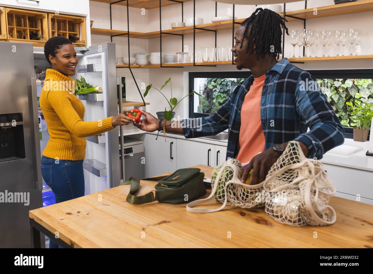 Happy african american couple unpacking groceries in kitchen Stock ...