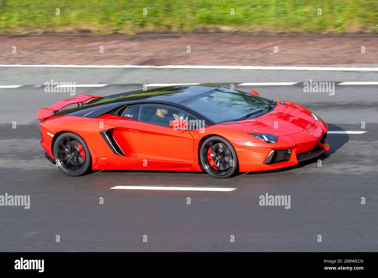 Lamborghini Aventador, a mid-engine super sports car travelling at speed on the M6 motorway in Greater Manchester, UK Stock Photo