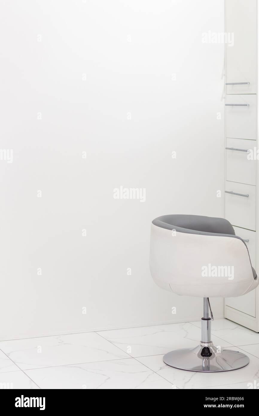 Modern white plastic chair in white room interior ceramic floor floor. Copy space. Stock Photo