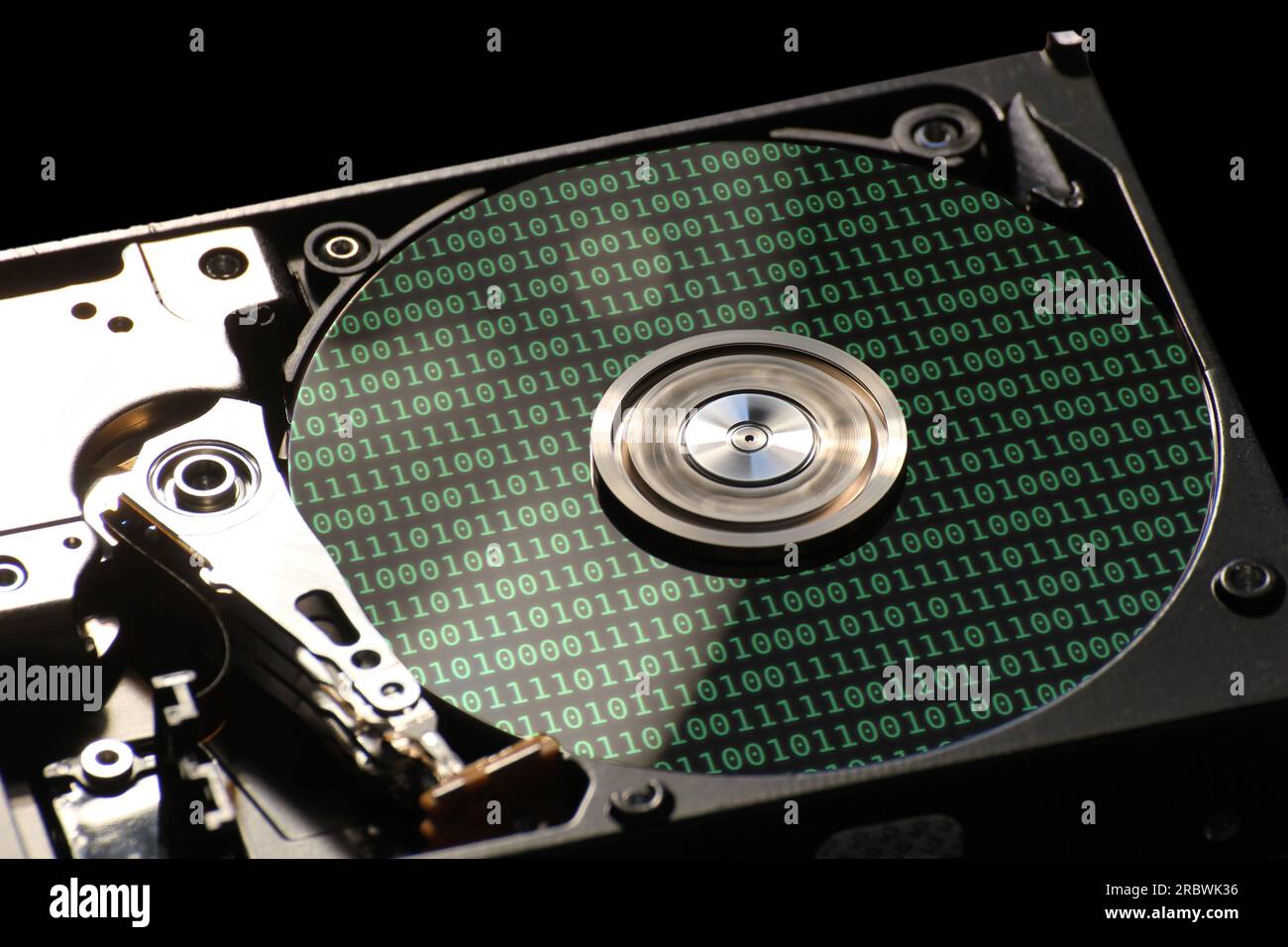 Hard disk on a black background with reflections on ones and zeros