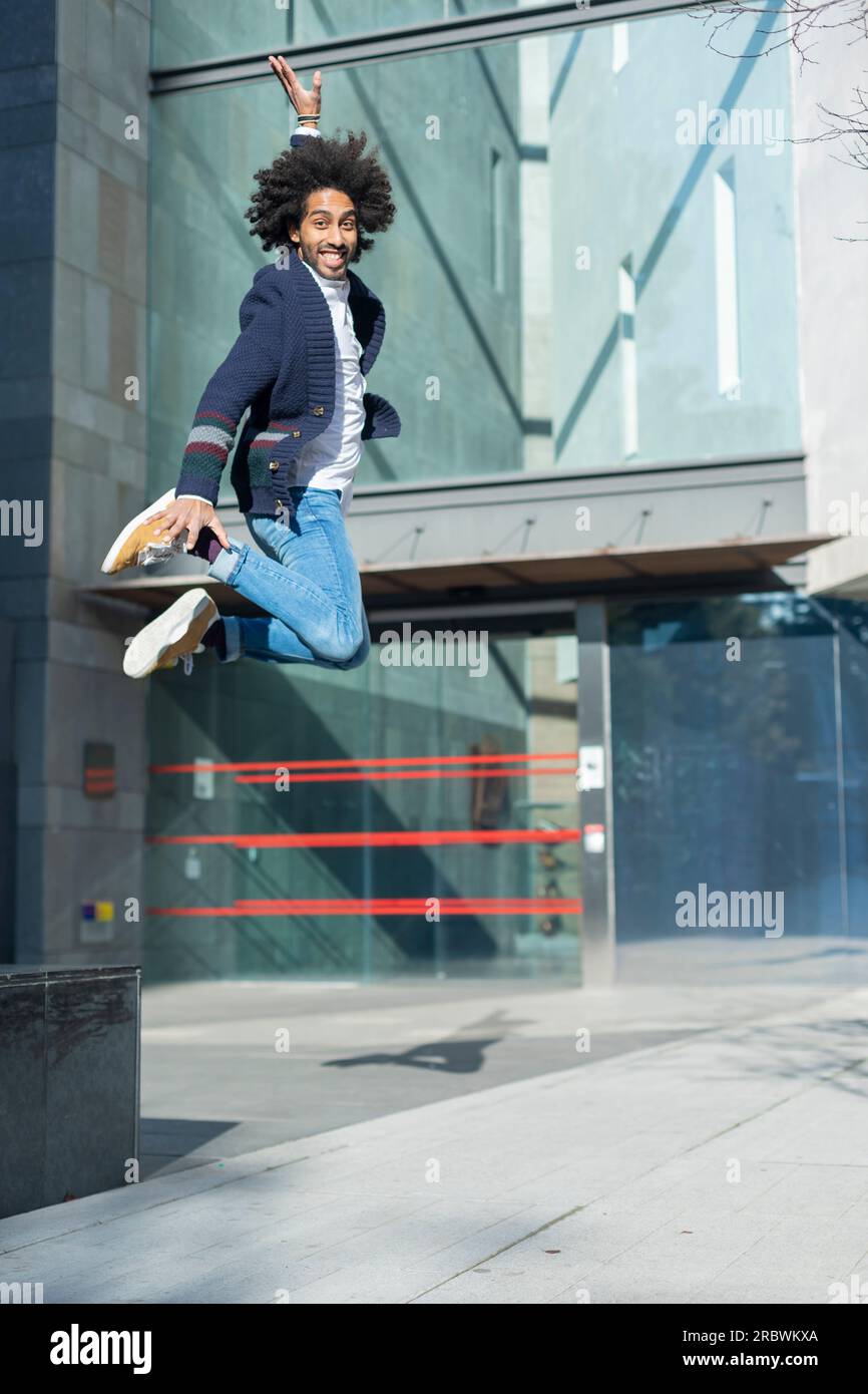 Happy young African American man jumping in the air. Stock Photo