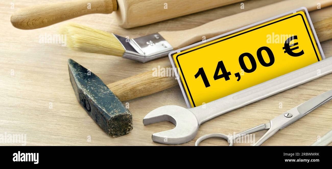 Werkzeug und gelbes Schild mit 14,00 Euro Mindestlohn in Deutschland Stock Photo