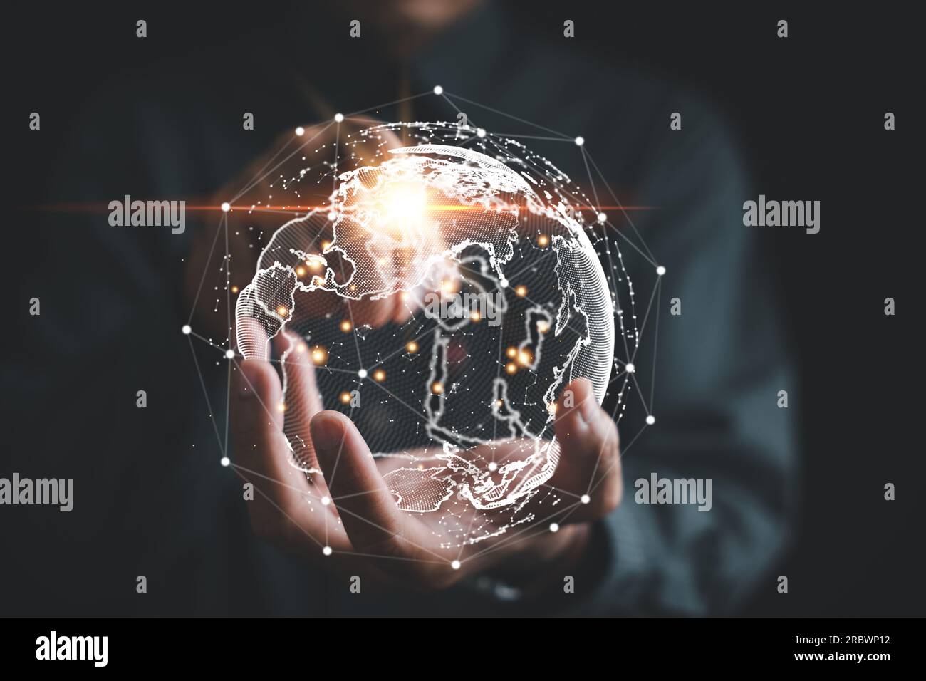 A businessman's hand holds a globe, illustrating seamless connectivity and data flow across global network Stock Photo