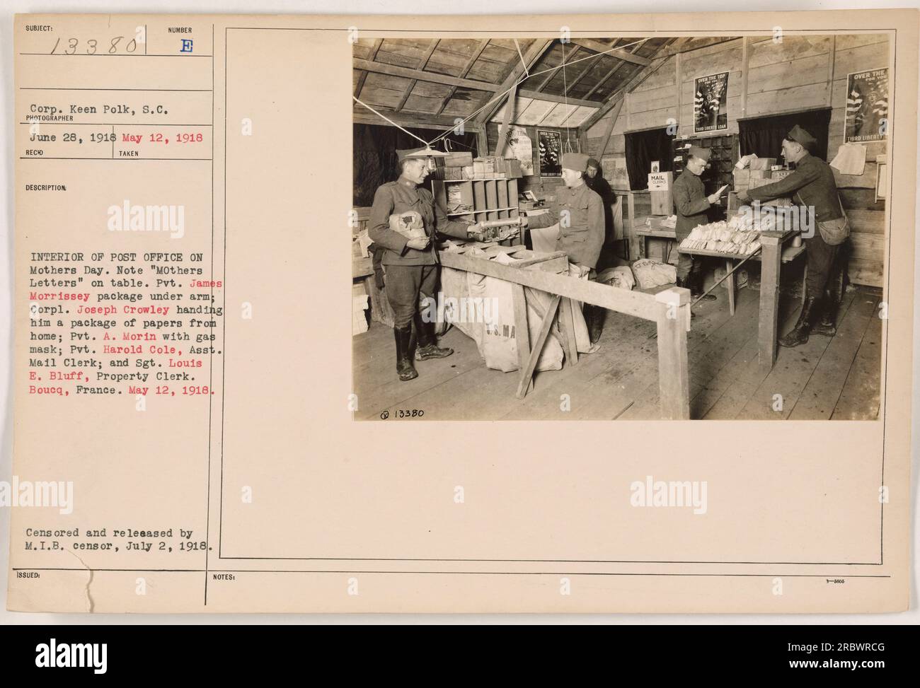 Interior of a post office in Boucq, France, on Mother's Day during World War One. Pvt. James Morrissey holds a package under his arm while Corp. Joseph Crowley hands him a package of papers from home. Pvt. A. Morin is seen with a gas mask, Pvt. Harold Cole is the assistant mail clerk, and Sgt. Louis B. Bluff is the property clerk. Censored and released by M.I.B. censor on July 2, 1918. Stock Photo