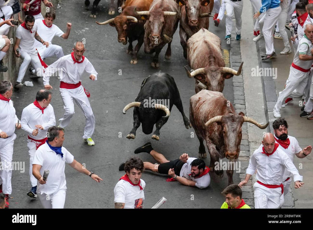 Pamplona, Spain. 11th July, 2023. A bull runner falls to the ground on Santo Domingo hill during the fifth running of the bulls of the San Fermin festival in Pamplona, Spain, on Tuesday, July 11, 2023. Thousands of people participated in the fifth of eight bull runs through the narrow streets of Pamplona's city center in the fiesta whose internationally fame is closely associated to Ernest Hemingway who describes it in his book 'The Sun Also Rises'. Photo by Paul Hanna/UPI Credit: UPI/Alamy Live News Stock Photo