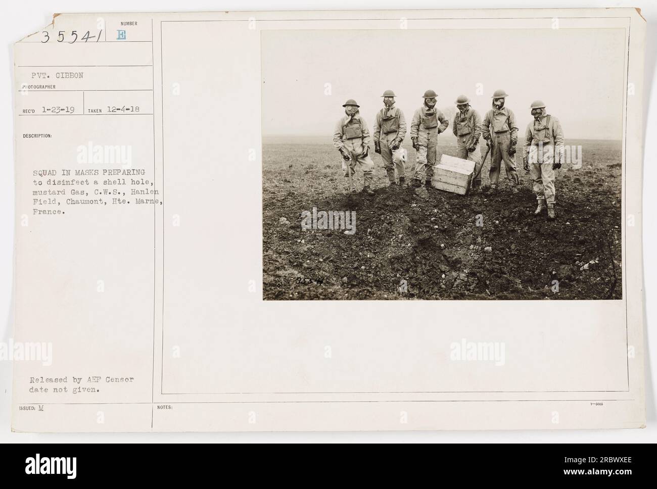 American soldiers wearing gas masks are shown preparing to disinfect a shell hole contaminated with mustard gas at Hanlen Field in Chaumont, Hte. Marne, France. The image was taken on December 4, 1918, and released by AEP Censor (date not provided). Stock Photo