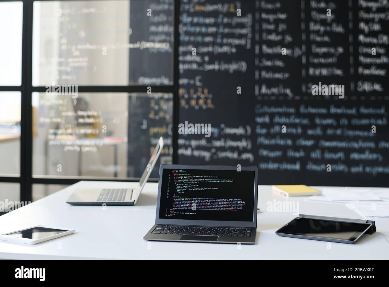 Workplace of IT teacher with laptop with codes on the screen and ...