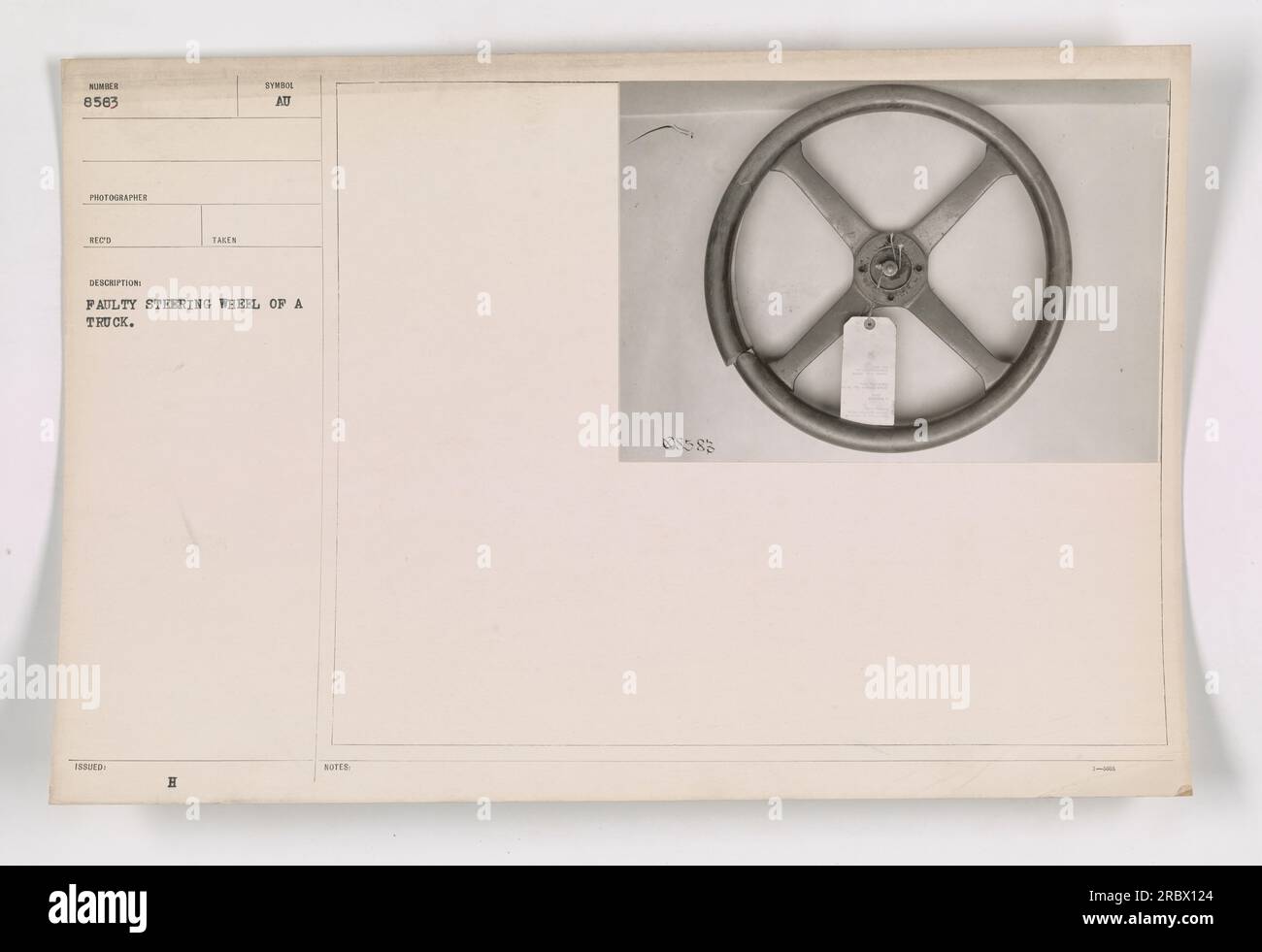 A photograph of a faulty steering wheel on a truck during World War I. The image, numbered 8563, was taken by an unidentified photographer and issued by REC. The truck appears to have a desorption problem with the steering wheel. Symbol notes indicate an 085-83 reference. Stock Photo