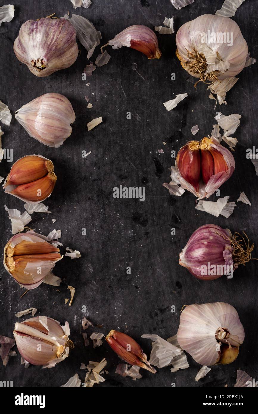 Fresh garlic bulbs and cloves grouped on black background. Flat lay ...