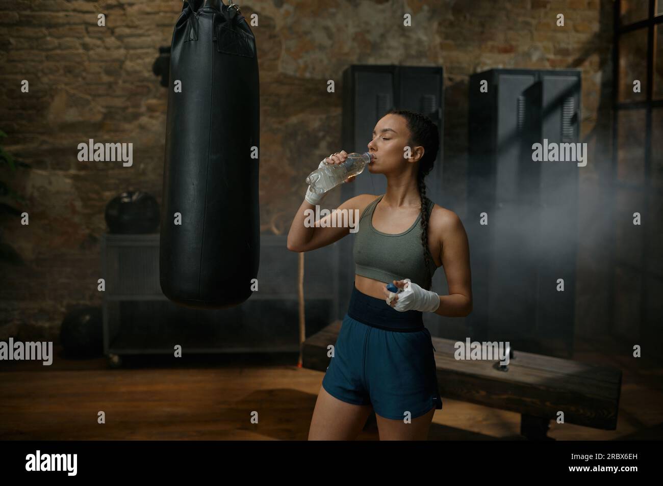 Woman boxer drinking water from plastic bottle quenching thirst after ...