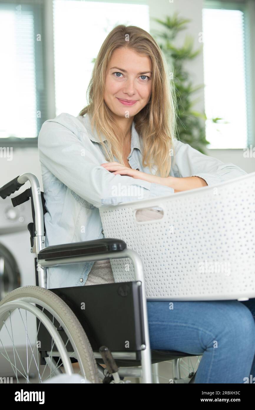 disabled young woman carrying basket to do laundry Stock Photo Alamy