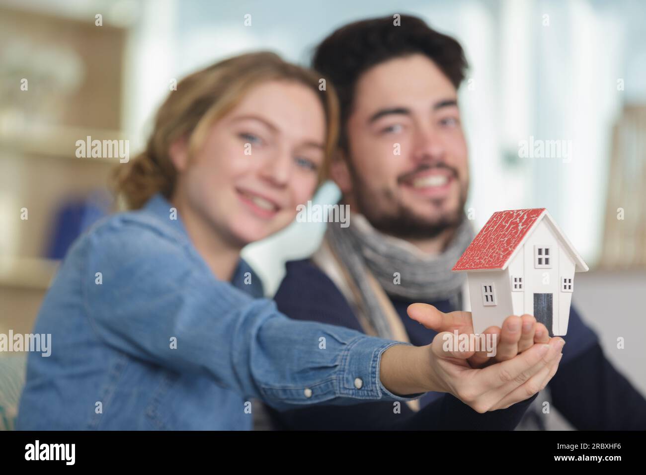 young couple holding small model house Stock Photo - Alamy